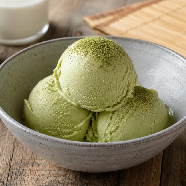Creamy Japanese matcha green tea ice cream served in a white bowl with matcha powder garnish